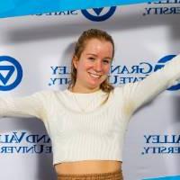 individuals smiling holding i am grand valley sign